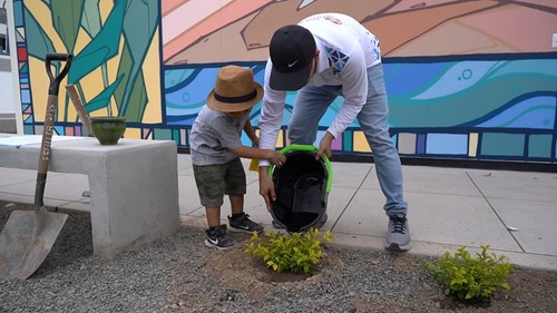 An adult and child doing landscaping work at a new school in Peru